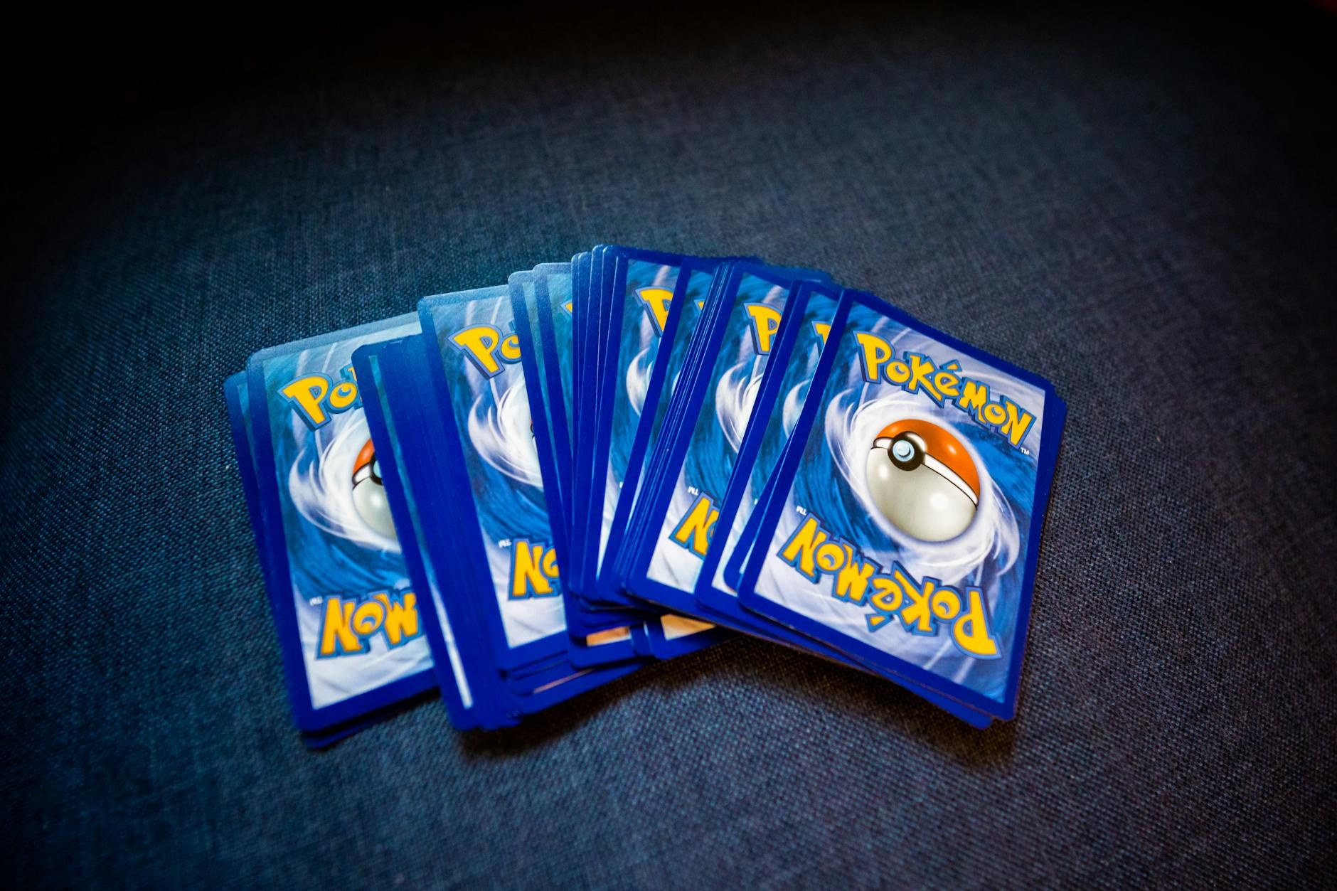 Tabletop playmat with trading cards, sleeves, and strategy notebook